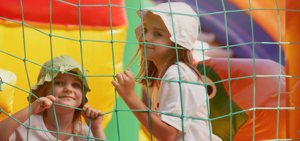 two little girls in a bounce castle smiling for the camera